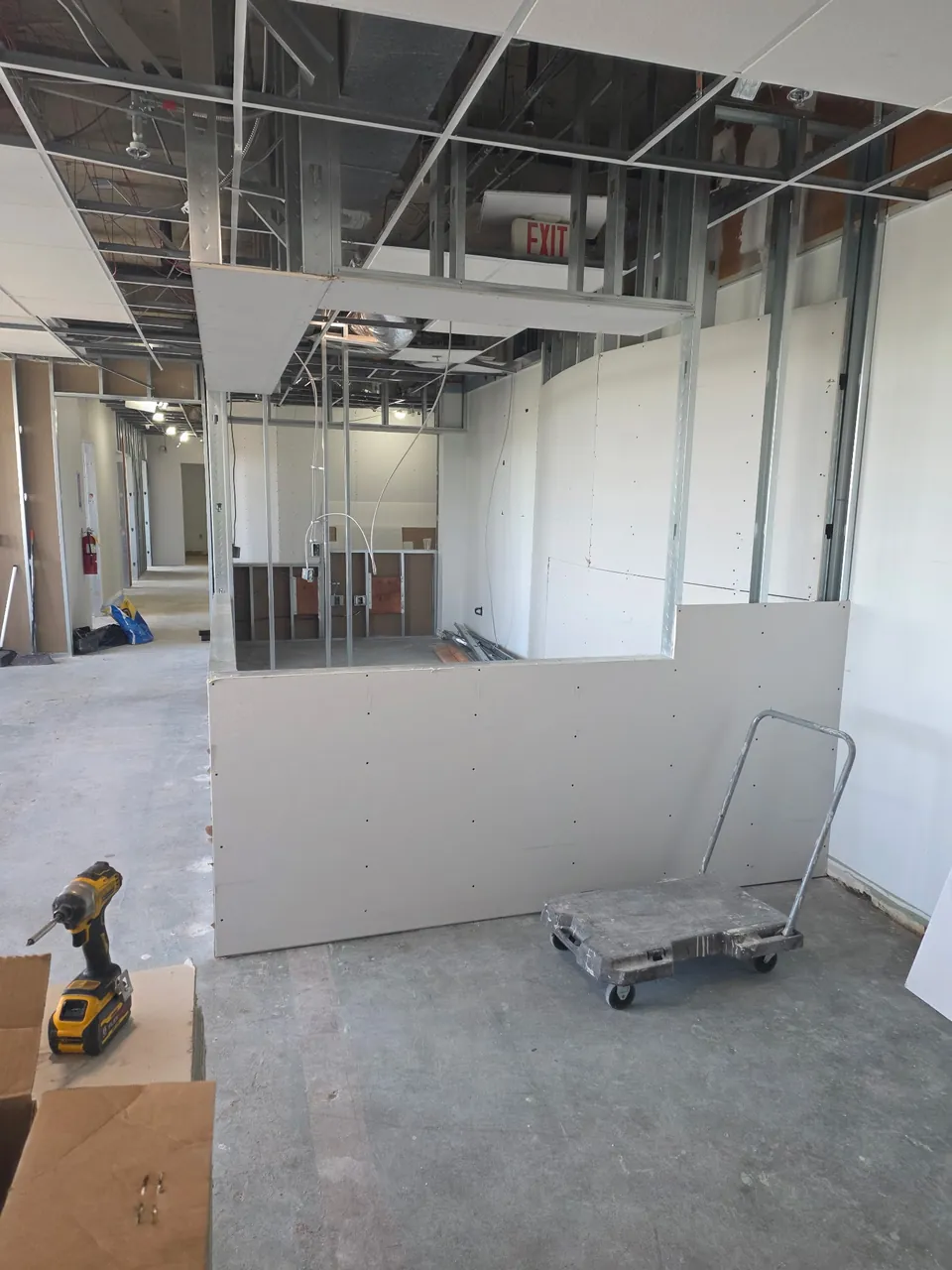 Nurse station bulkhead and partial-height walls being hung with drywall