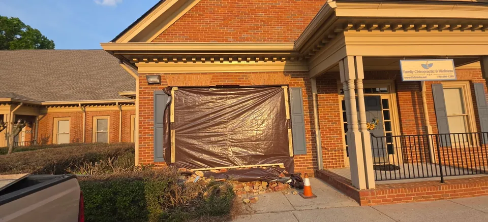 Damaged office building wall covered with a tarp for weather protection before reconstruction